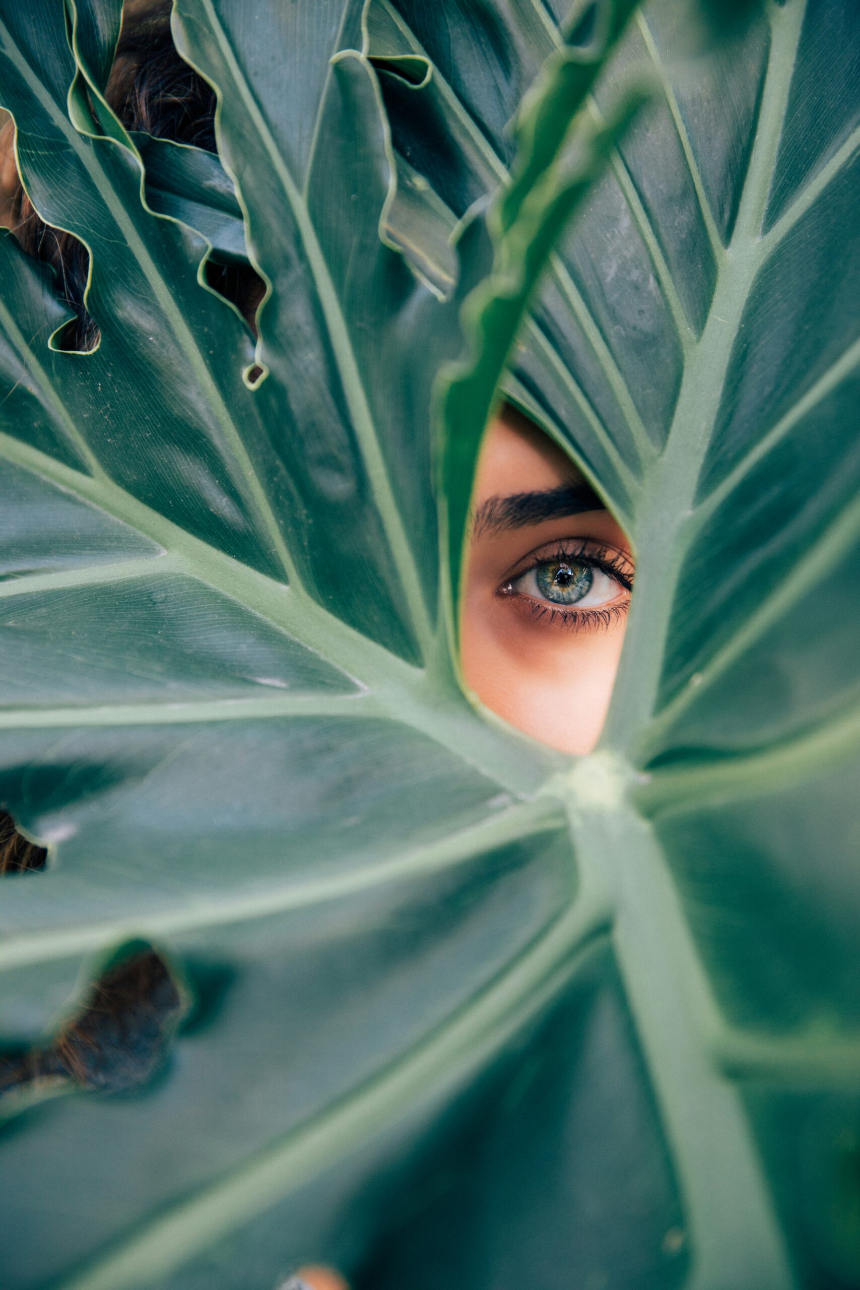 woman peeking over green